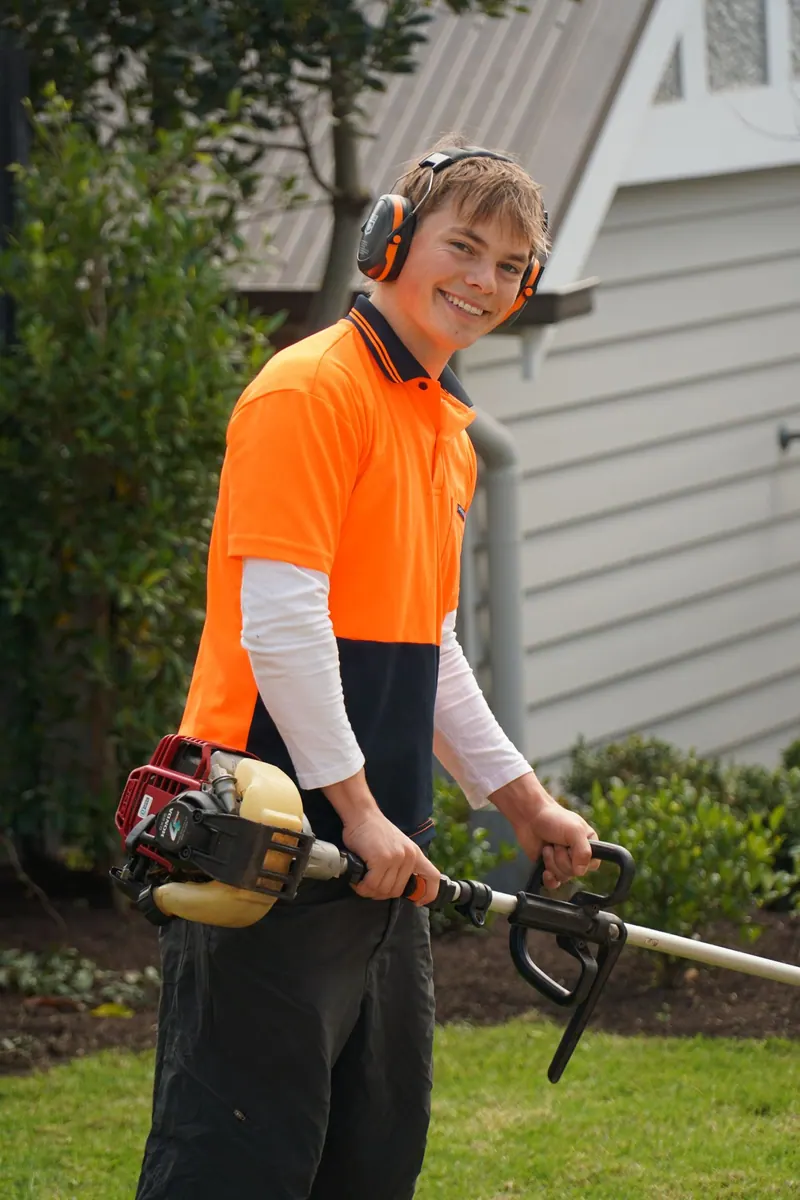 Henry of HP Gardening smiling, holding a line trimmer